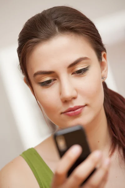 Kvinna tittar på mobiltelefon — Stockfoto