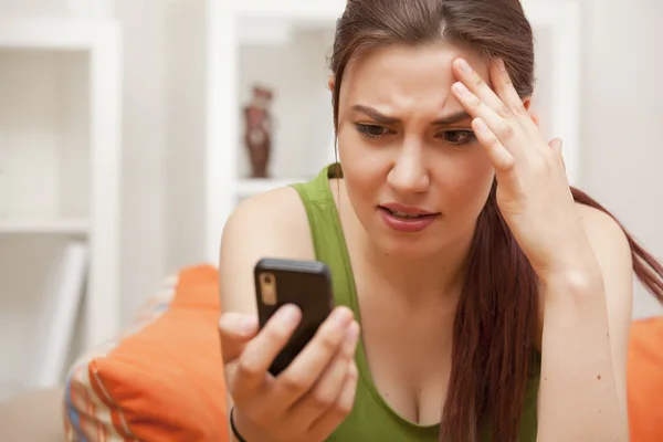 Chockad kvinna som tittar på telefon — Stockfoto