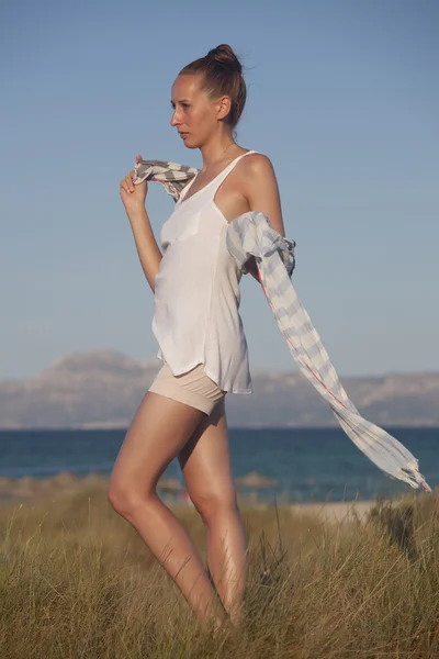 Женщина на пляже с шарфом — стоковое фото