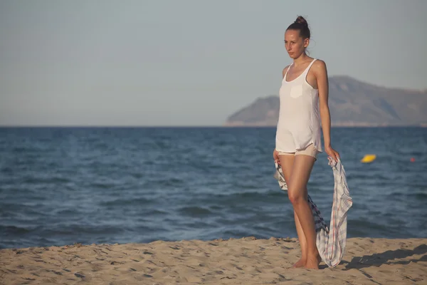 Vrouw met hoofddoek op het strand — Stockfoto
