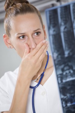 Shocked doctor with x-ray scans clipart