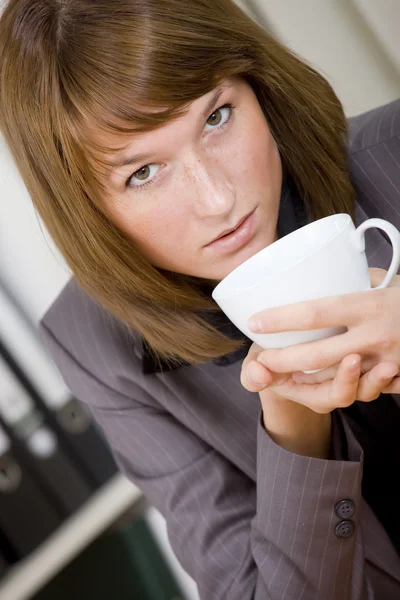 在办公室吃喝咖啡休息的女人 — 图库照片