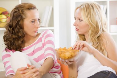 Two women on sofa talking clipart