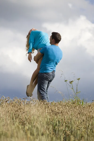 Мужчина держит женщину в воздухе — стоковое фото