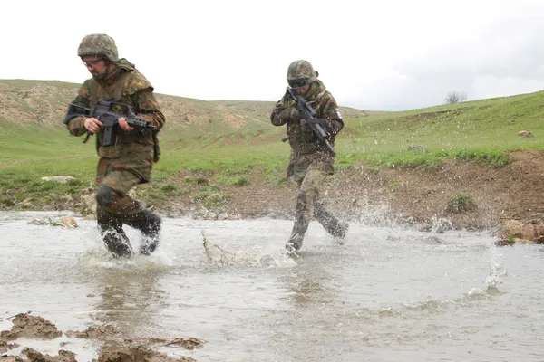 Soldiers running across the water — Stock Photo, Image