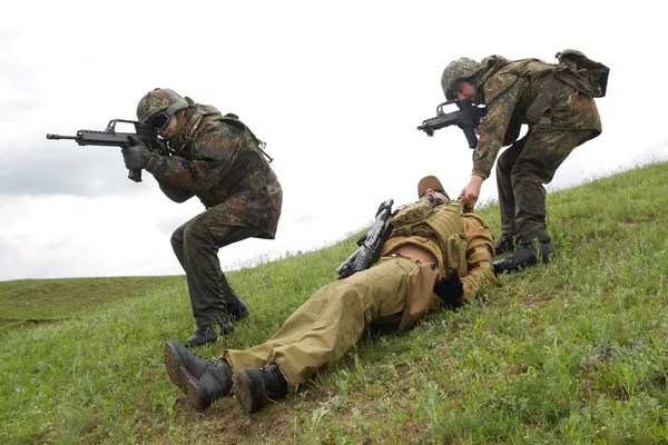 Солдаты спасают своего раненого напарника — стоковое фото