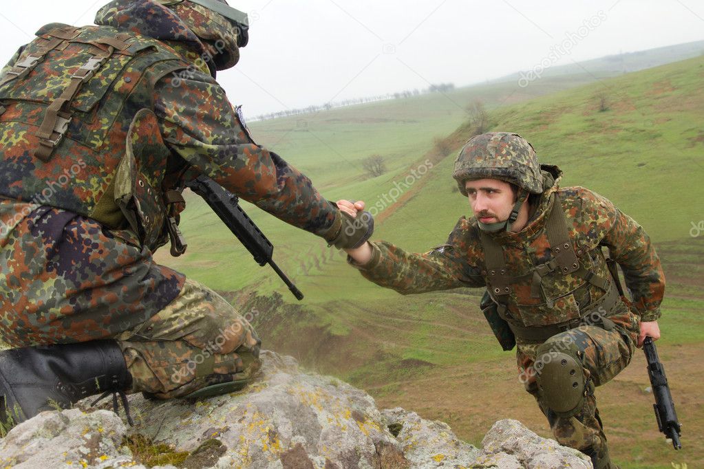 Soldier gives hand to his partner