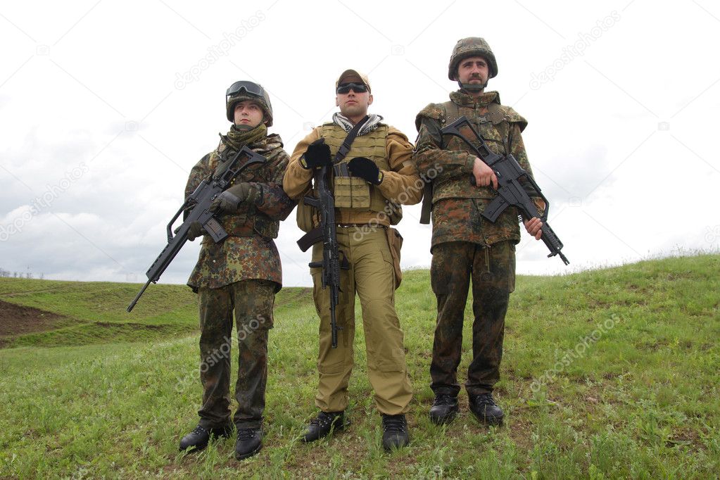 Three soldiers outdoors posing