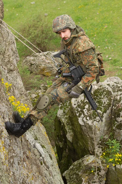 Armed soldier hanging on the rope — Stock Photo, Image