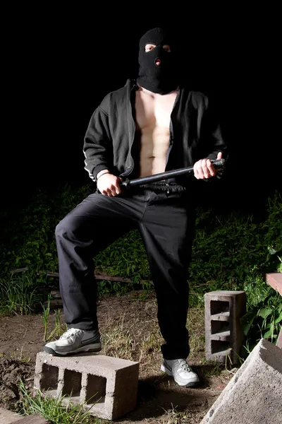 Gangster with baton outdoors at night — Stock Photo, Image