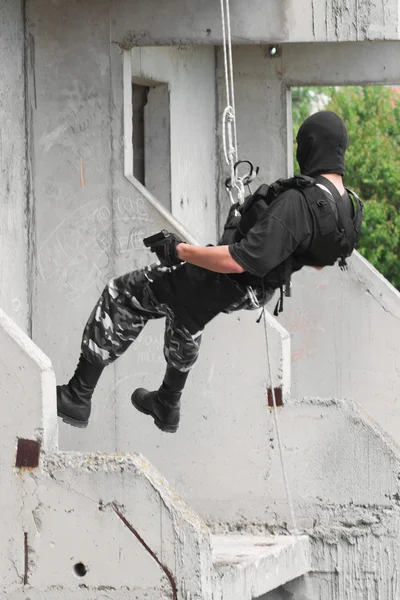 Żołnierz uzbrojony w czarnej masce pojmując budowania — Zdjęcie stockowe