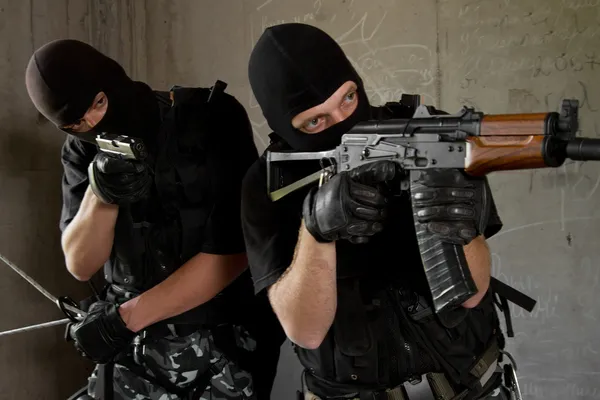 Soldados em máscaras pretas com armas — Fotografia de Stock