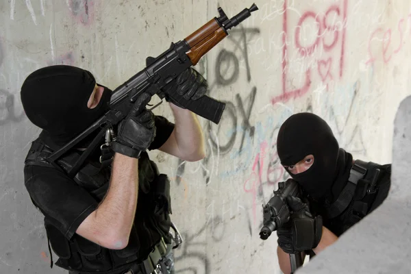 Soldiers in black masks moving upstairs with weapons — Stock Photo, Image