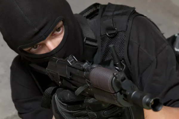 Soldado con máscara negra apuntando con rifle AK-47 —  Fotos de Stock