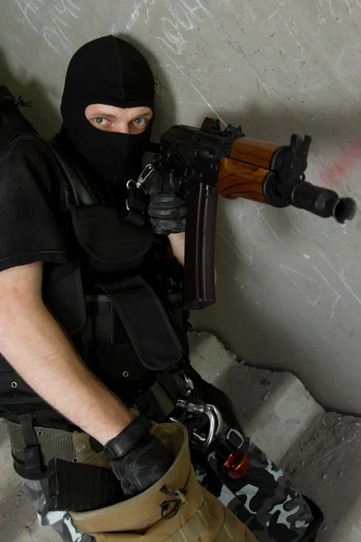 Soldaat in zwart masker opladen ak-47 geweer — Stockfoto