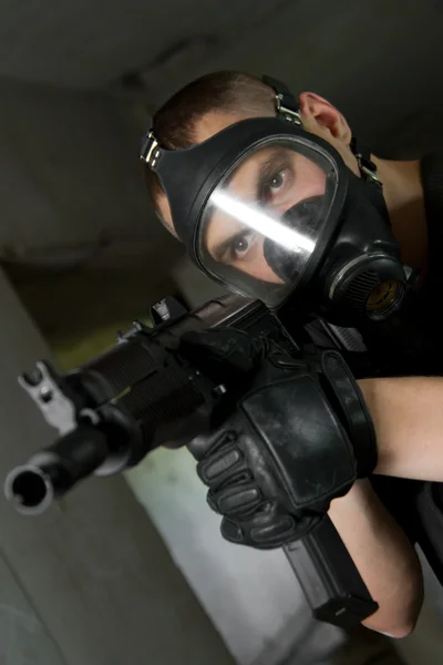 Soldaat in gasmasker richt met ak-47 geweer — Stockfoto