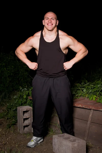 Atletische jonge man in de sloppenwijken nachts — Stockfoto