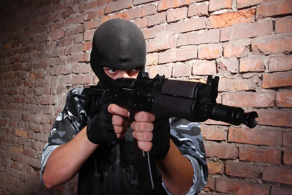 Soldado armado con máscara negra apuntando con un arma —  Fotos de Stock