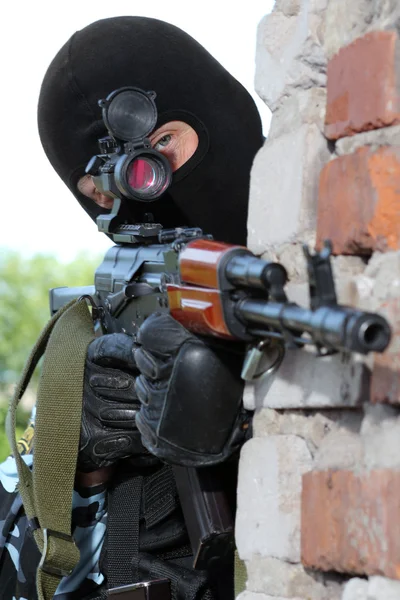 Stock image Armed soldier in black mask targeting with a gun