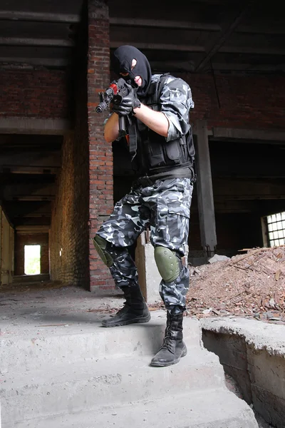 Вооруженный террорист в черной маске целится из пистолета — стоковое фото