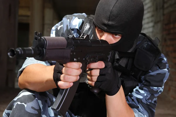 Soldado armado com máscara preta apontando com uma arma — Fotografia de Stock
