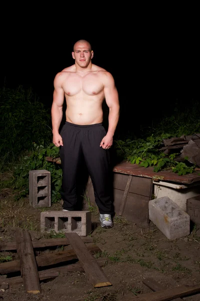 Sportovní mladý muž ve slumech v noci — Stock fotografie