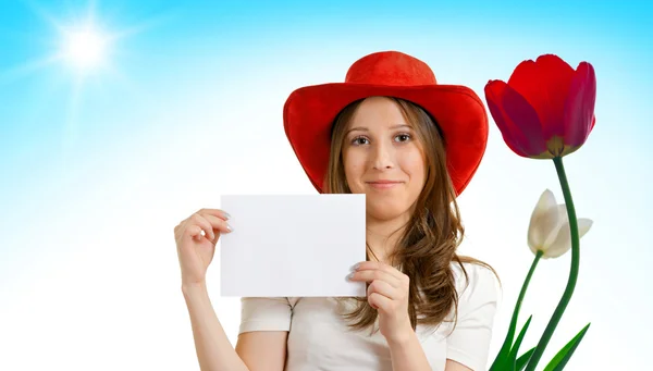 Girl in a red hat with tulips — Stock Photo, Image