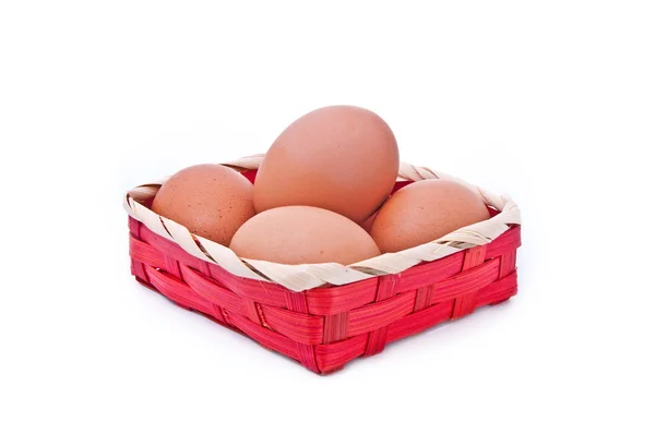Яйца в плетеной красной корзине — стоковое фото