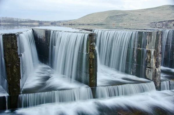 Water stroomt over een dam — Stockfoto