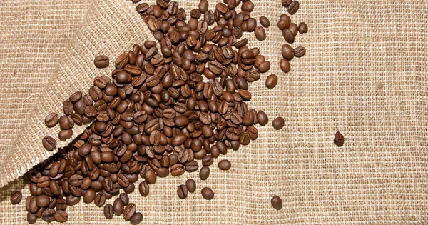 Κόκκοι καφέ στο φόντο λινάτσα — Φωτογραφία Αρχείου