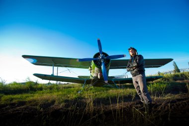 Pilot in front of vintage plane clipart