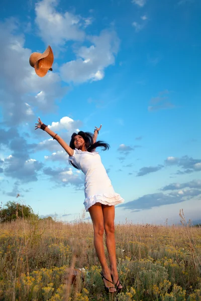 Woman is jumping and throwing her hat — Stock Photo, Image