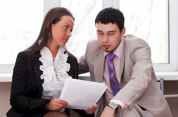 Geschäftsfrau und Geschäftsmann sitzen in Büro-Lobby — Stockfoto