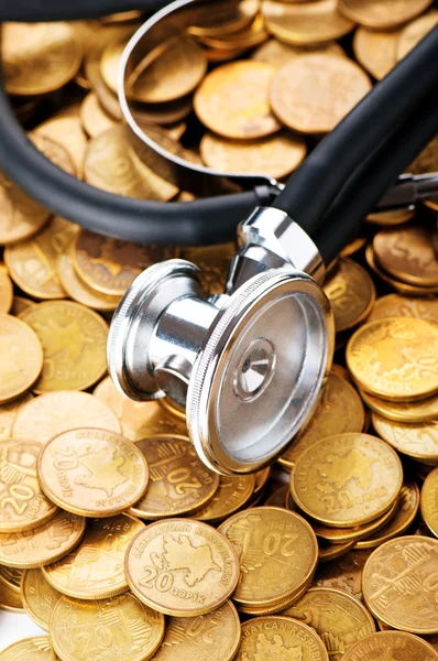 Conceito de cuidados de saúde caros com moedas e estetoscópio — Fotografia de Stock