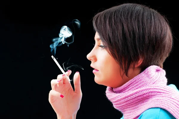 Mladá dívka kouření na černé — Stock fotografie