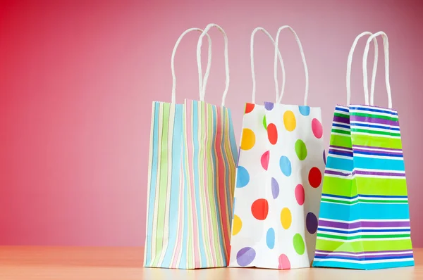 グラデーション背景とカラフルな紙のショッピング バッグ — ストック写真