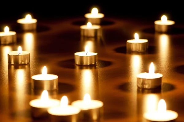 Mnoho hořících svíček s mělkou hloubkou pole — Stock fotografie