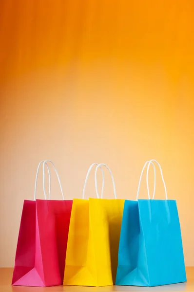 Sacos de compras contra fundo gradiente — Fotografia de Stock