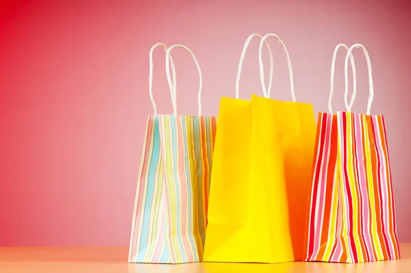 Bolsas de compras de papel de colores contra el fondo degradado —  Fotos de Stock