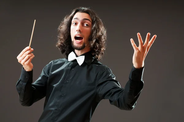 Lustiger Dirigent vor dunklem Hintergrund — Stockfoto