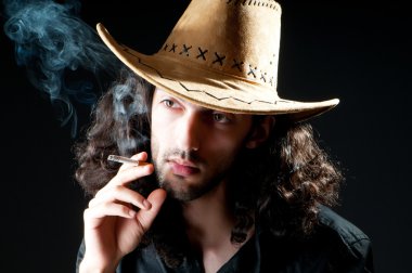 Man in cowbow hat smoking clipart