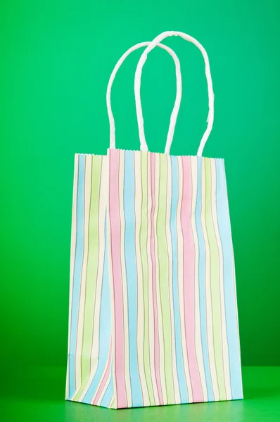 Sacos de compras de papel coloridos contra fundo gradiente — Fotografia de Stock