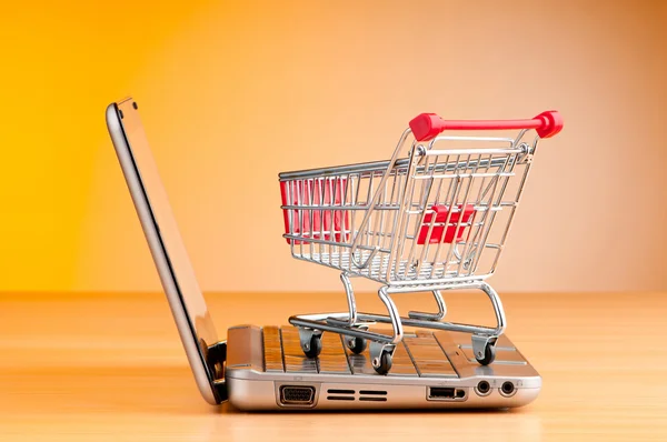 Internet online shopping concept with computer and cart Royalty Free Stock Photos