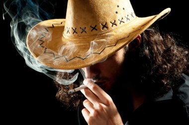 Man in cowbow hat smoking clipart