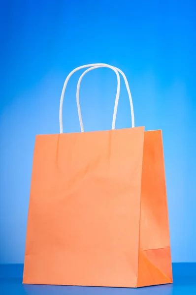 Colourful paper shopping bags against gradient background — Stock Photo, Image