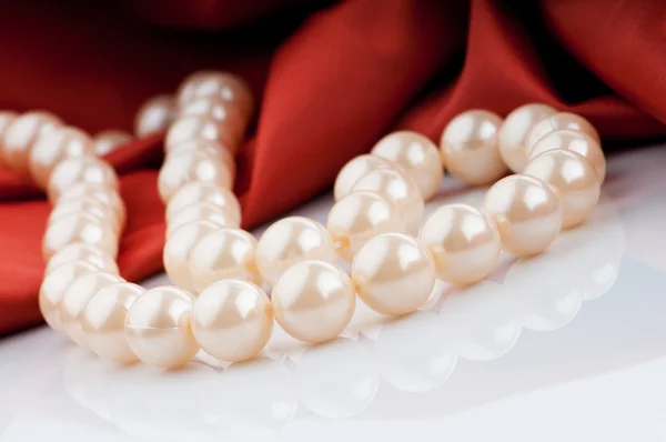 Collar de perlas sobre fondo satinado —  Fotos de Stock