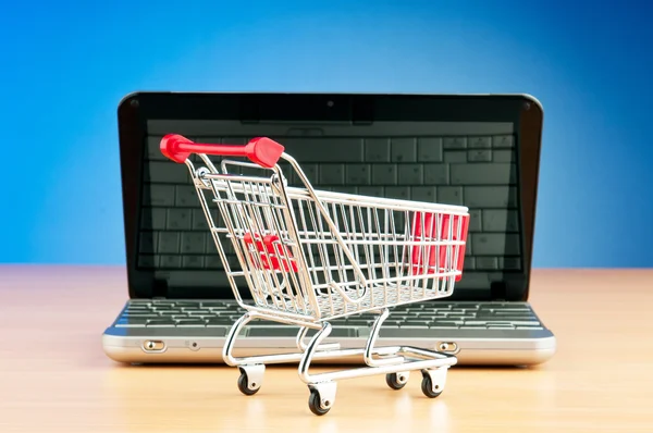 Internet online shopping concept with computer and cart — Stock Photo, Image