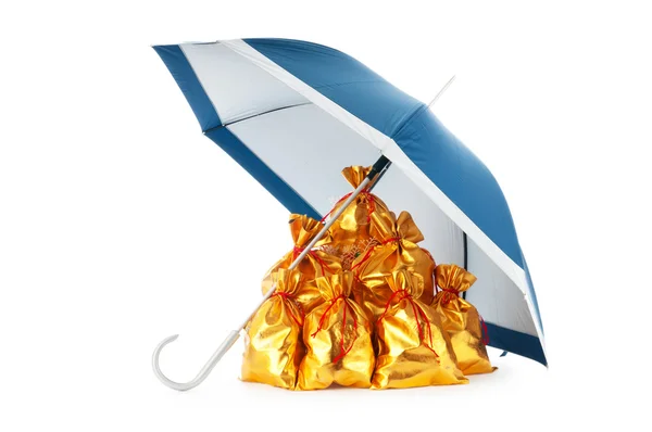 Golden sacks under protection of umbrella — Stock Photo, Image
