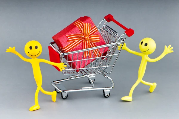 Smileys with gift box in the shopping cart — Stock Photo, Image
