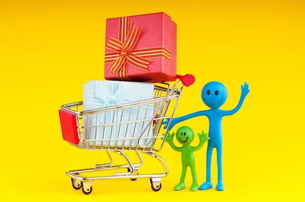 Smileys met de doos van de gift in de winkelwagen — Stockfoto